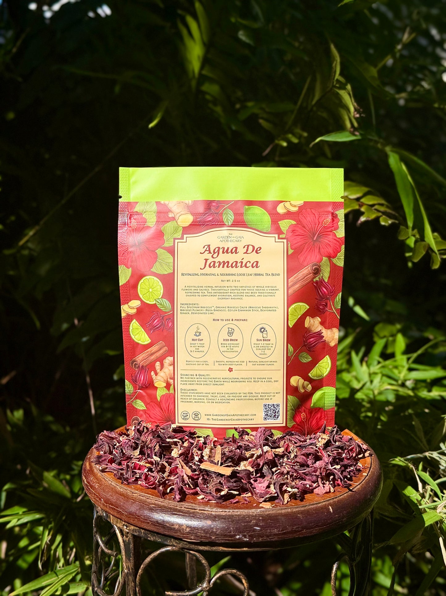 Agua De Jamaica - Revitalizing Hydrating & Nourishing Loose Leaf Tea blend package on a table surrounded by hibiscus petals.