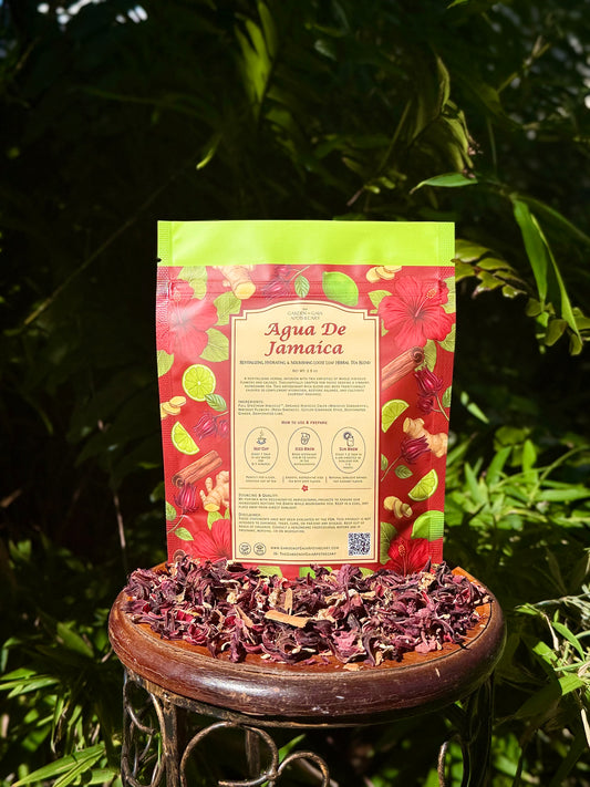 Agua De Jamaica - Revitalizing Hydrating & Nourishing Loose Leaf Tea blend package on a table surrounded by hibiscus petals.