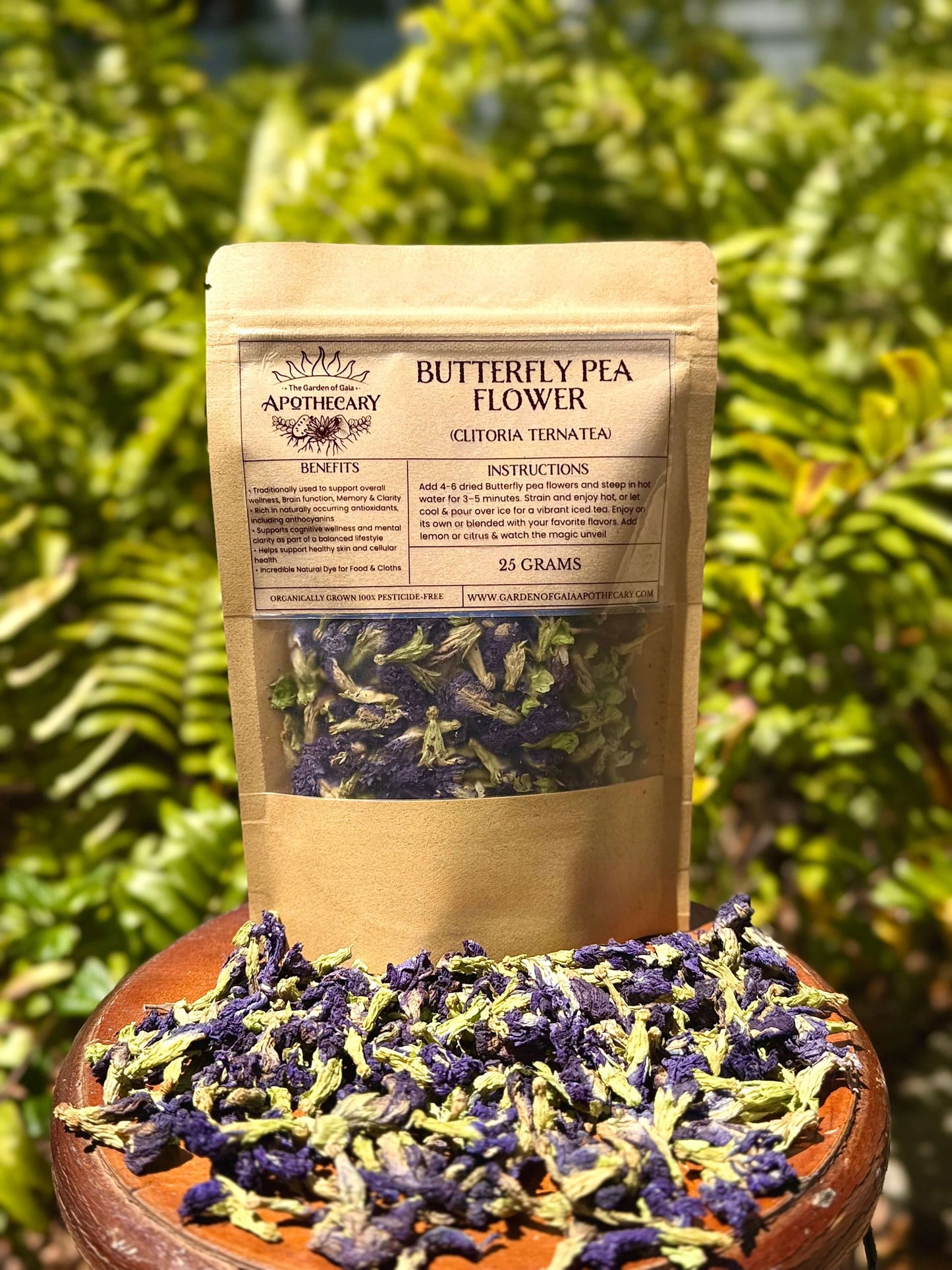 Butterfly pea flower packaging with Butterfly pea flower flowers on a wooden surface against a green leafy background