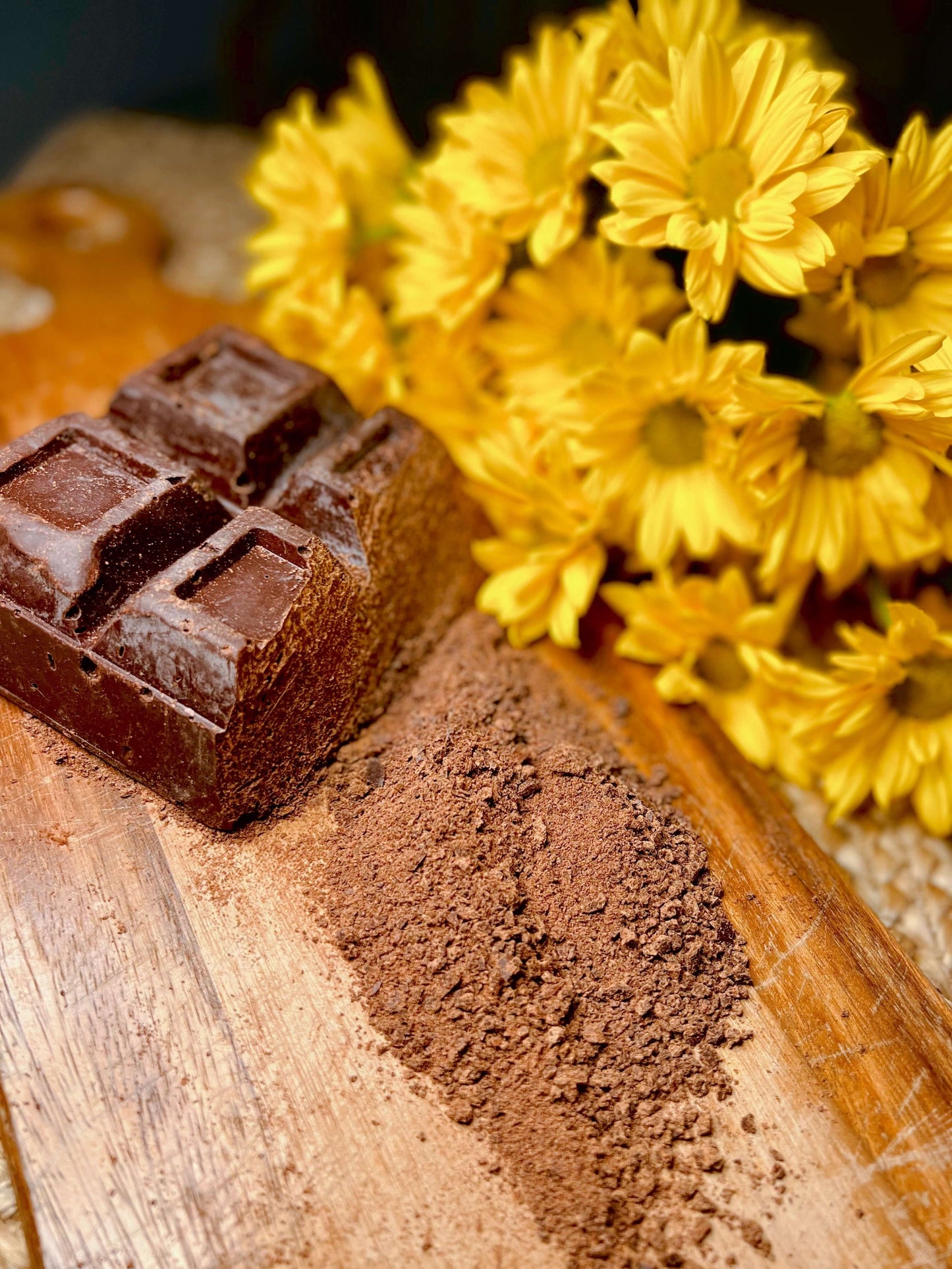 Ceremonial Grade Costa Rican Cacao - Bribri displayed with cocoa powder and yellow flowers.
