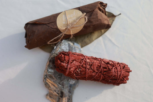 Dragon's Blood Sage - Smudge Stick with packaging and sage leaf on a white background.