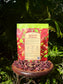 Agua De Jamaica - Revitalizing Hydrating & Nourishing Loose Leaf Tea blend package on a table surrounded by hibiscus petals.