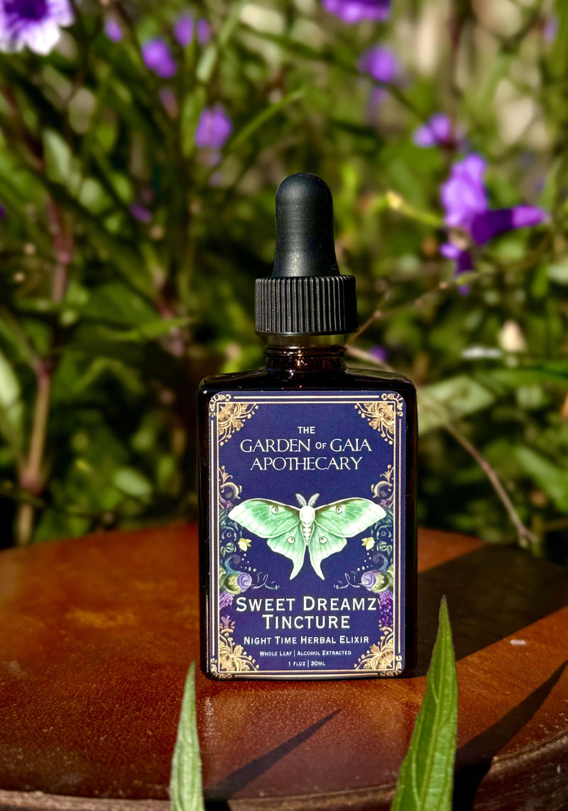Sweet Dreamz Tincture-Nervous System Relaxation Elixir in a bottle with a butterfly design against purple flowers.