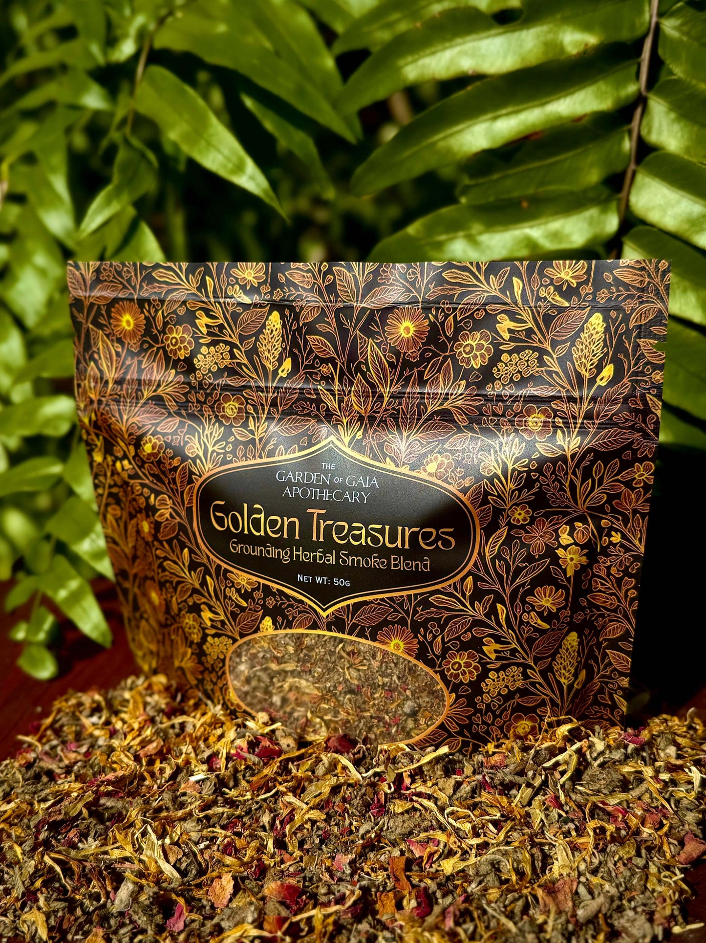 Golden Treasures-herbal smoke blend packaging on display with colorful herbs and flowers.