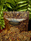 Golden Treasures-herbal smoke blend packaging on display with colorful herbs and flowers.
