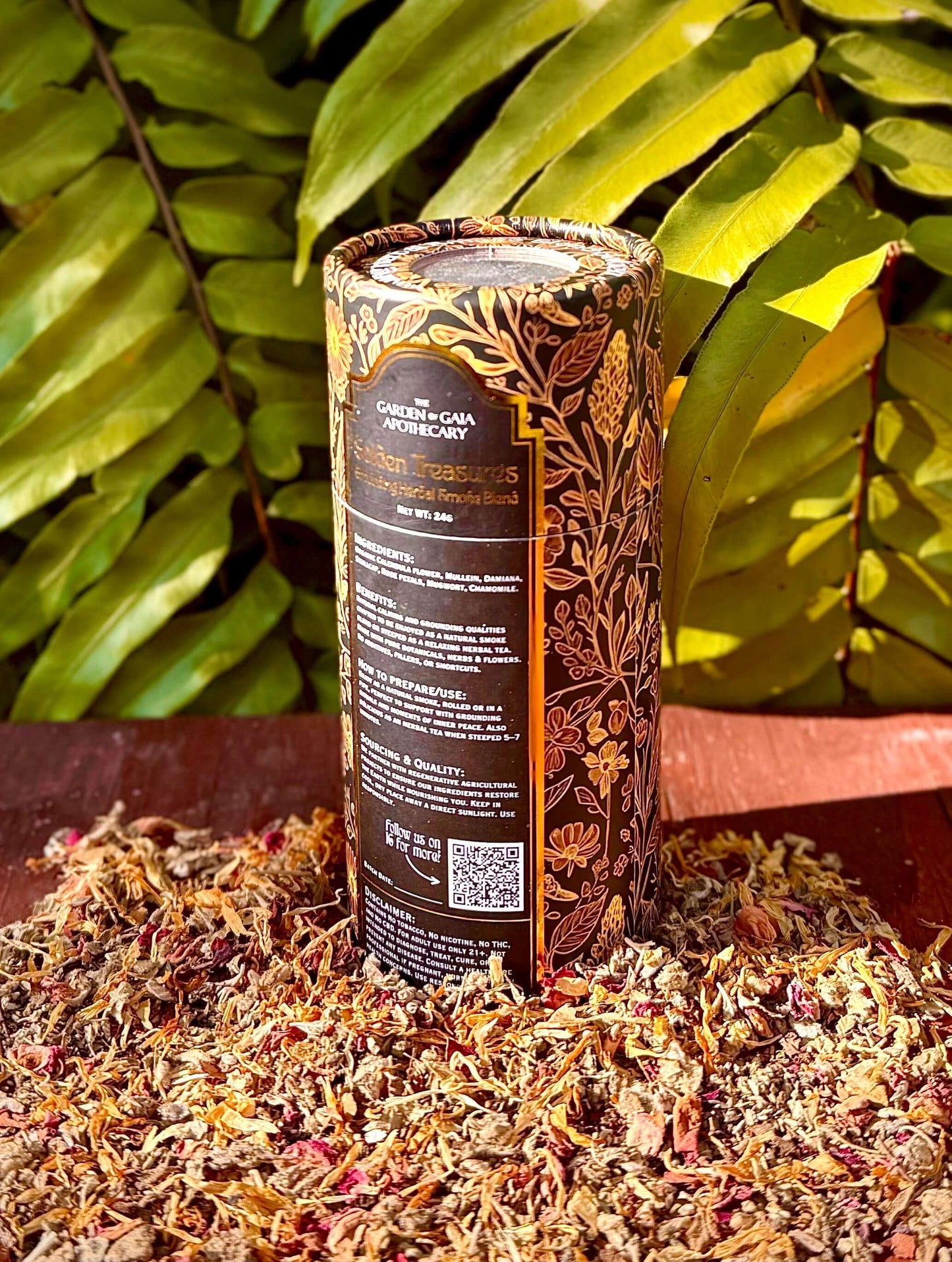 Golden Treasures-herbal smoke blend packaging surrounded by herbs and flowers, set against green foliage.