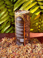 Golden Treasures-herbal smoke blend packaging surrounded by herbs and flowers, set against green foliage.