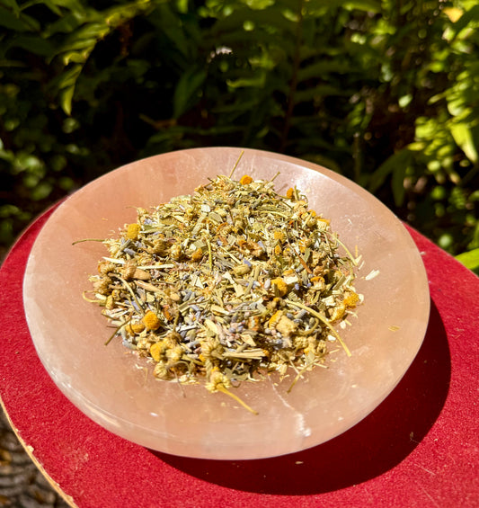 Dried chamomile lavender and oat straw on a pink stone plate with a natural background
