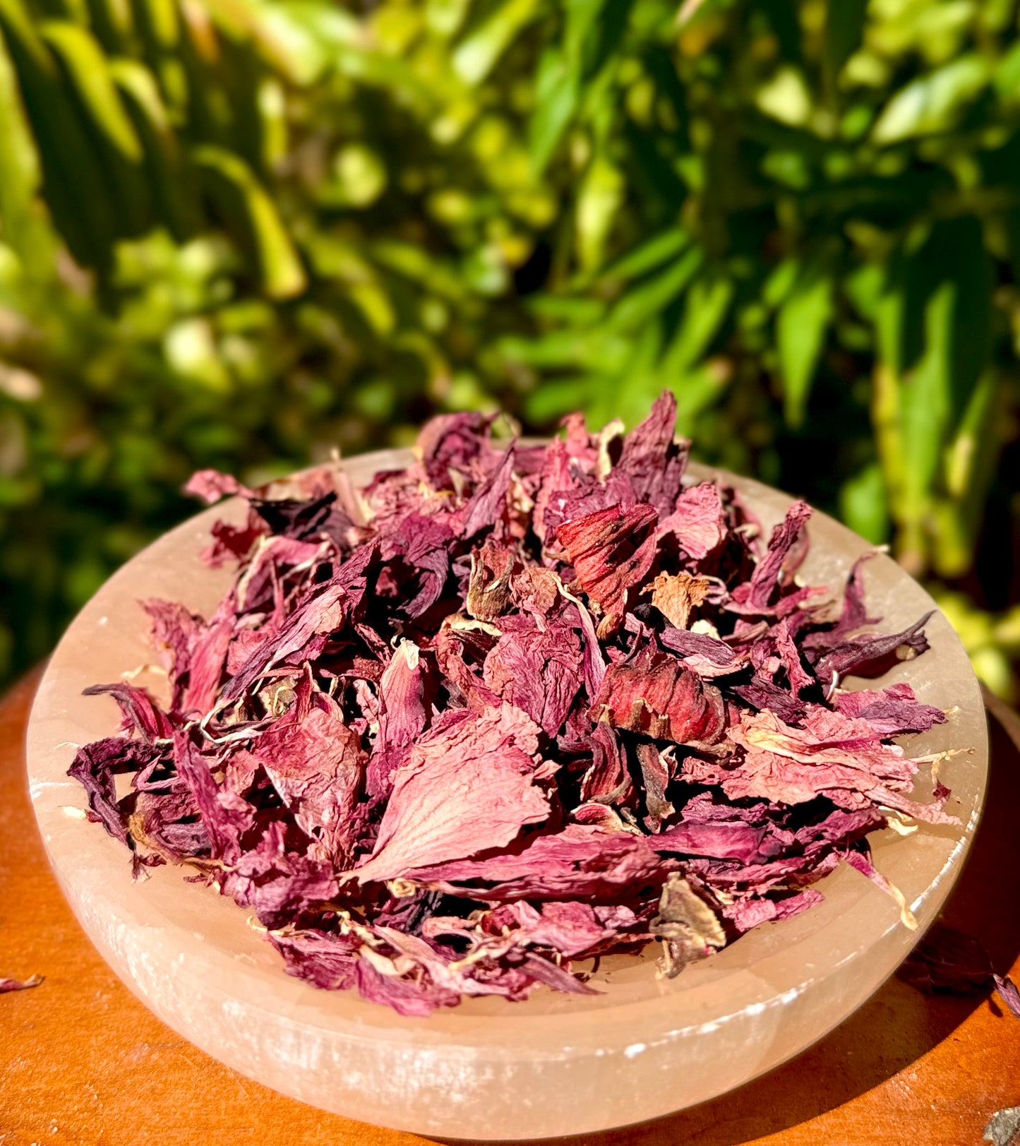 Dried hibiscus leaves in a stone bowl with a natural green background