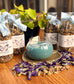 Butterfly Chai tea jars with a teapot filled with blue liquid on a wooden surface.