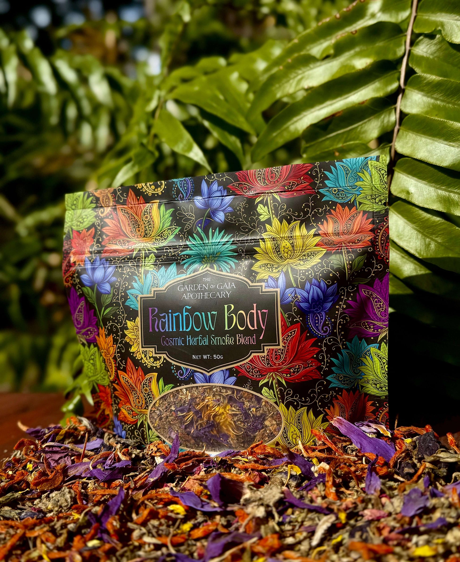 Rainbow Body-Cosmic Herbal Blend packaging with vibrant floral designs, surrounded by herbal leaves.