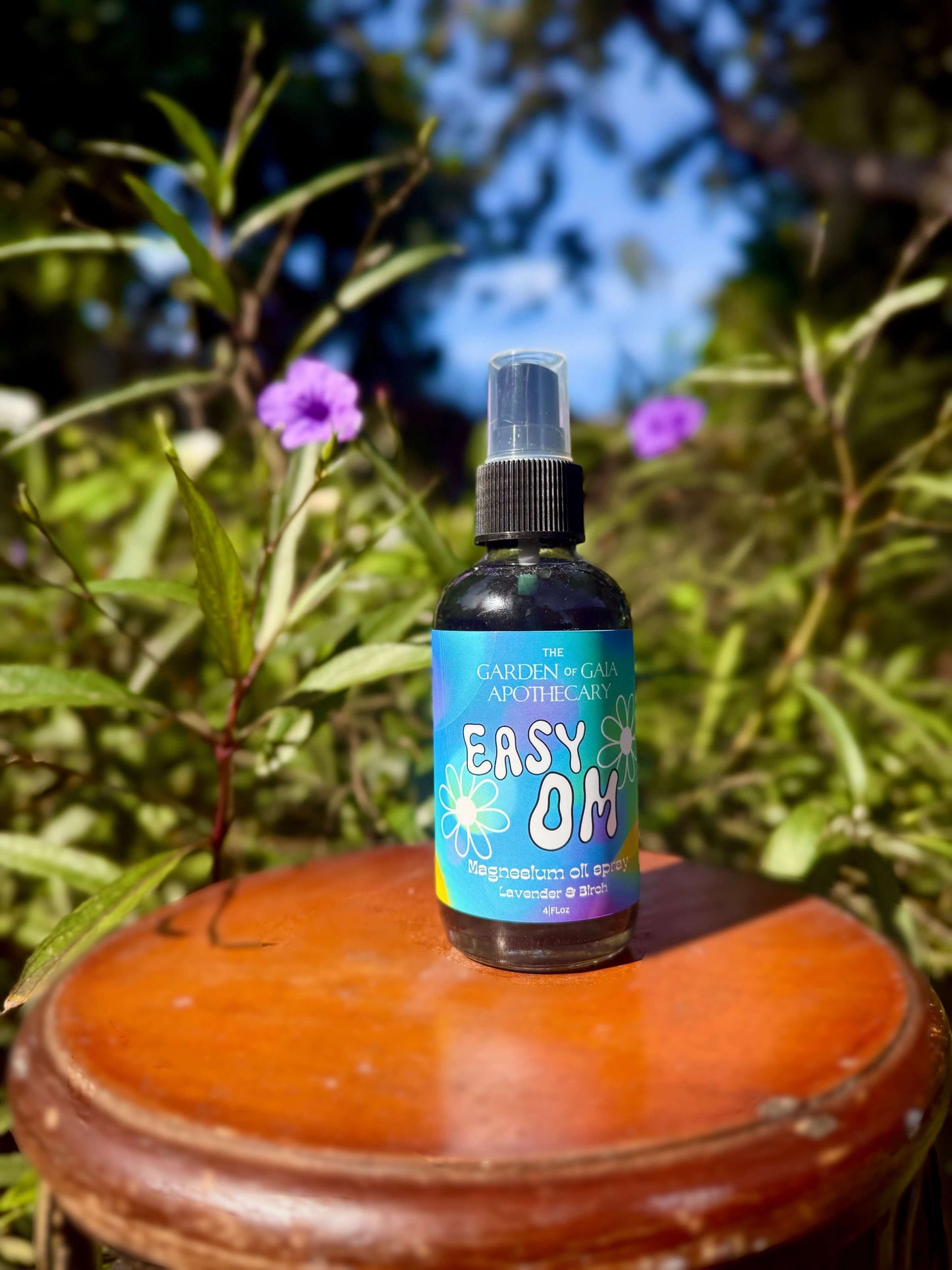 Easy OM-Magnesium Fine Mist Spray bottle on wooden surface with greenery in background.