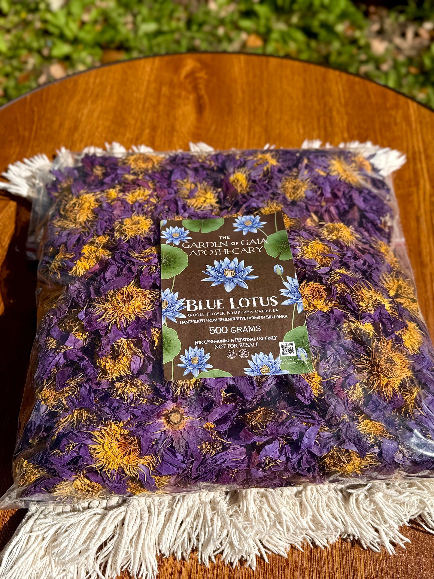 Packaged dried 500 grams bulk blue lotus flowers with a label on a wooden surface